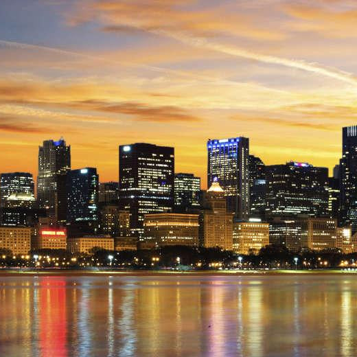 Chicago skyline at sunset with city buildings and lake reflection