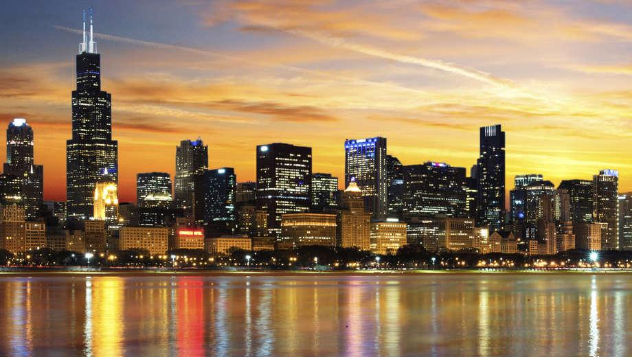 Chicago skyline at sunset with city buildings and lake reflection