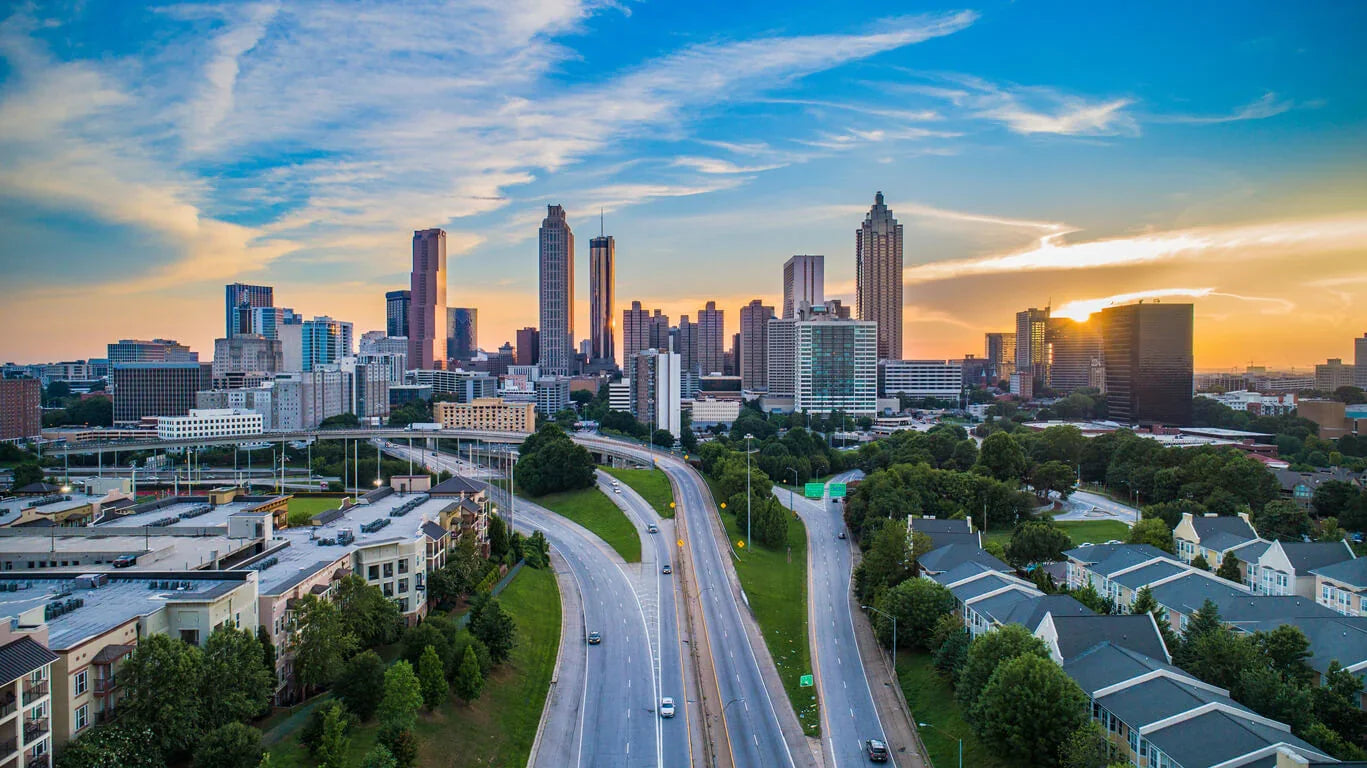 Atlanta skyline at sunset with skyscrapers, highways, and residential buildings