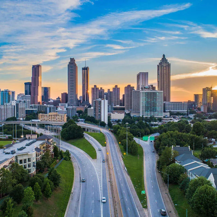 Atlanta skyline at sunset with skyscrapers, highways, and residential buildings