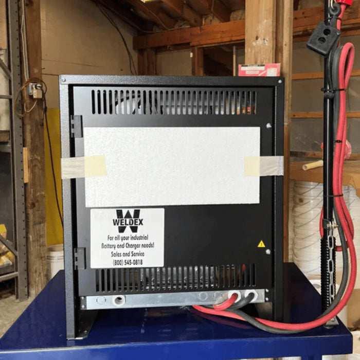 Industrial battery charger on steel stand with cables in warehouse setting